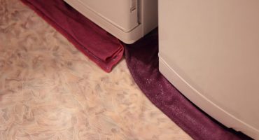 Water flows from under the refrigerator and accumulates under the drawers.